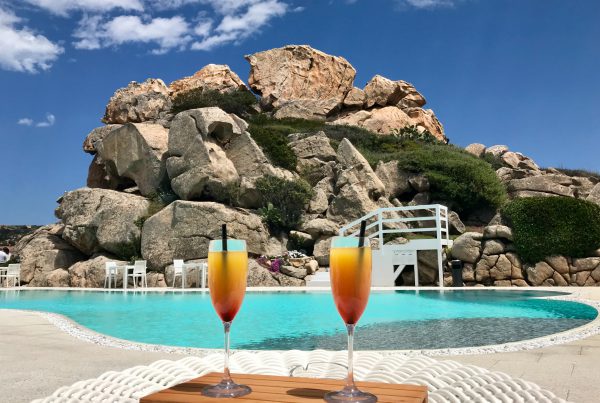 Two cocktails on a table beside a pool.